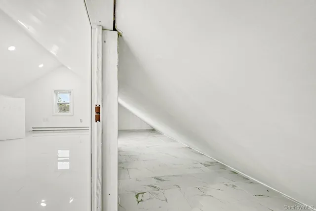 a view of a hallway with white walls and floors