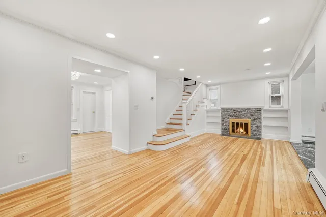 a view of a livingroom with wooden floor and staircase
