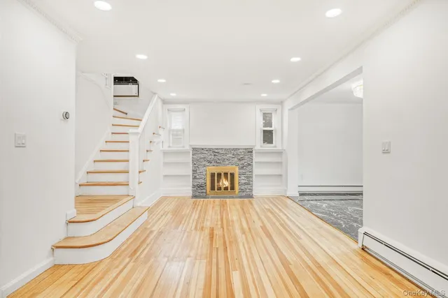 a view of a livingroom with wooden floor and a fireplace