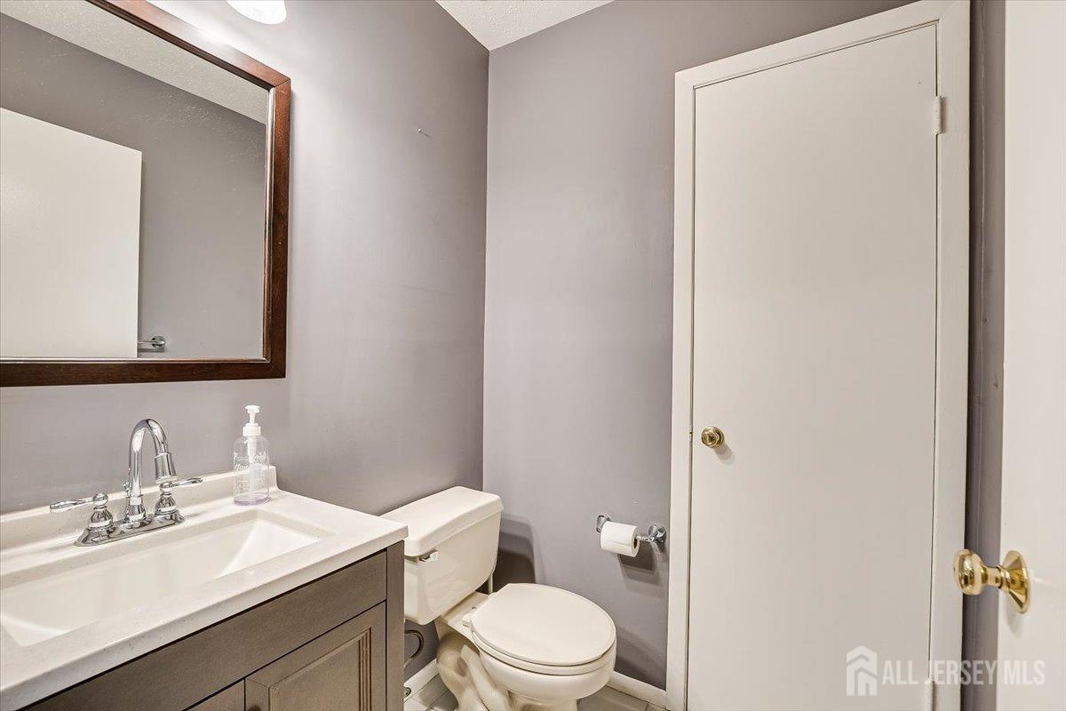 230 Nebula Road Piscataway, NJ 08854 - Photo 16 of 33 a bathroom with a toilet a sink a vanity and mirror