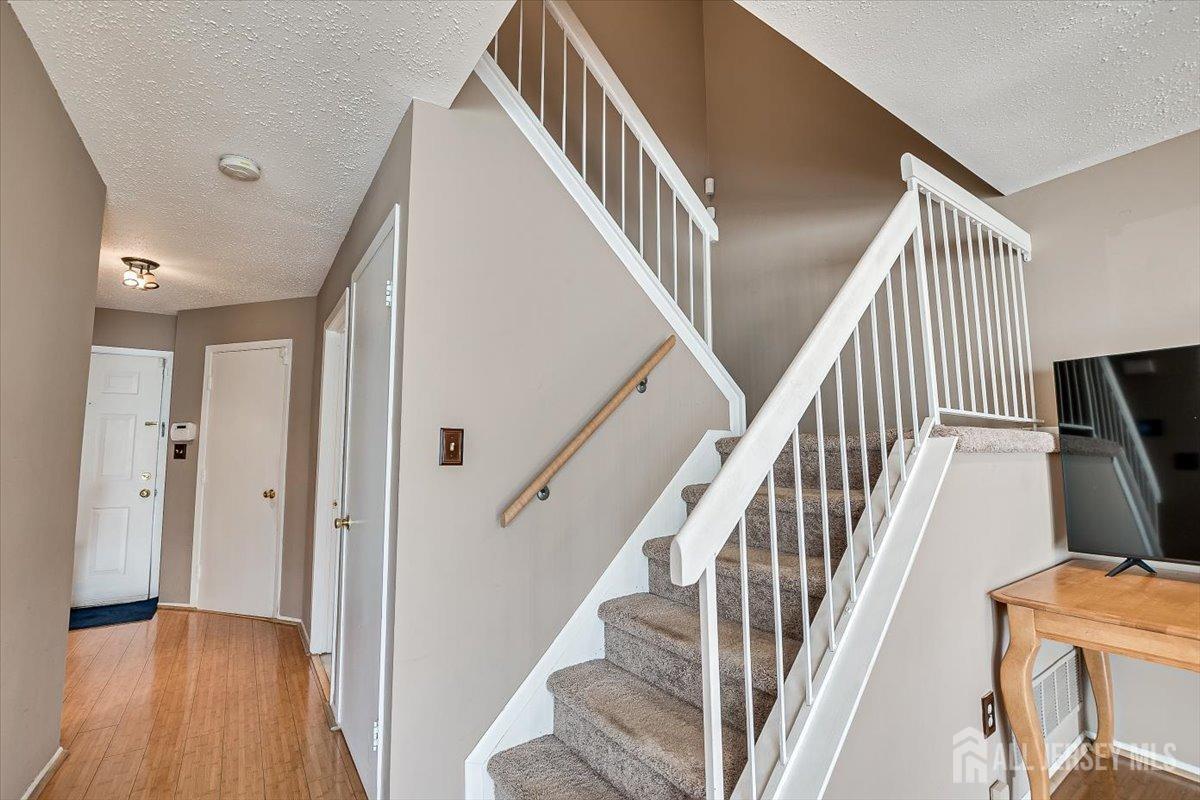230 Nebula Road Piscataway, NJ 08854 - Photo 17 of 33 wooden floor and an entryway with wooden floor and stairs