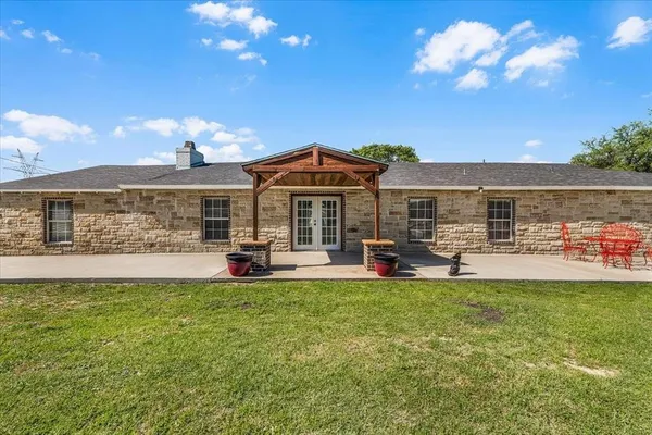 a view of a house with a garden and patio