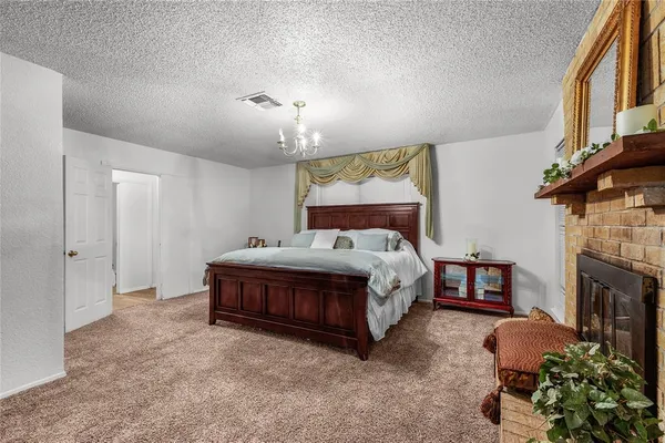 a spacious bedroom with a bed and a fireplace