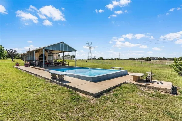 a swimming pool with outdoor seating and yard