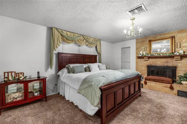a bedroom with a bed a chandelier and dresser