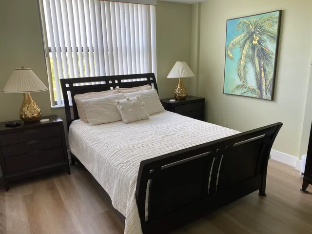 a bedroom with a bed and a lamp on dresser