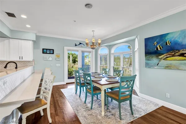 a view of a dining room with furniture wooden floor and chandelier