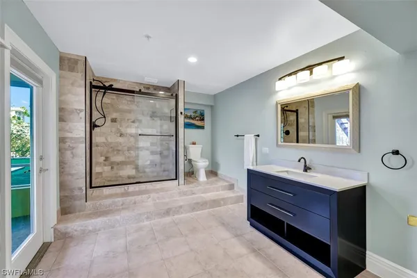 a bathroom with a granite countertop toilet sink and mirror