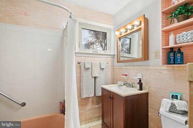 a bathroom with a sink and mirror with bathtub