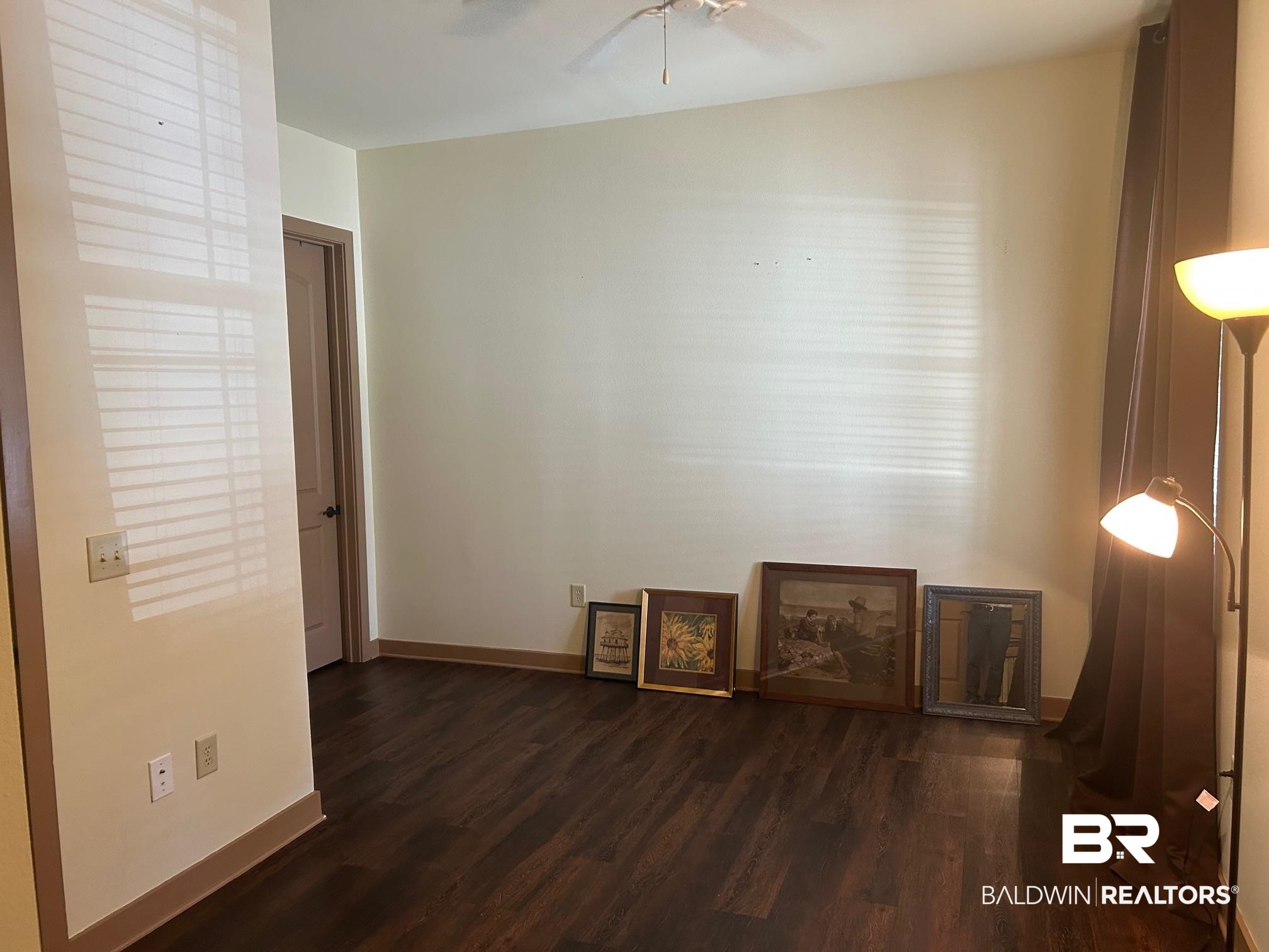 1430 Regency Road, Unit J102 Gulf Shores, AL 36542 - Photo 11 of 11 Empty room with dark wood-type flooring and ceiling fan
