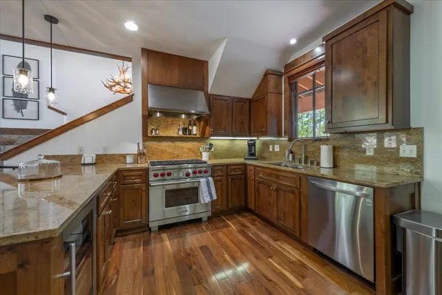 a kitchen with stainless steel appliances granite countertop a sink and stove
