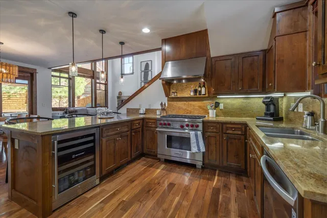 a kitchen with stainless steel appliances granite countertop a stove a sink and a wooden cabinets