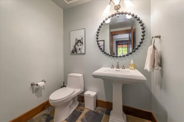 a bathroom with a toilet a sink and mirror