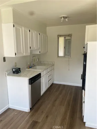 a kitchen with a sink cabinets and wooden floor