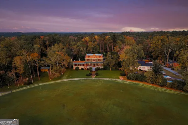 an aerial view of a house with a yard basket ball court and a fountain