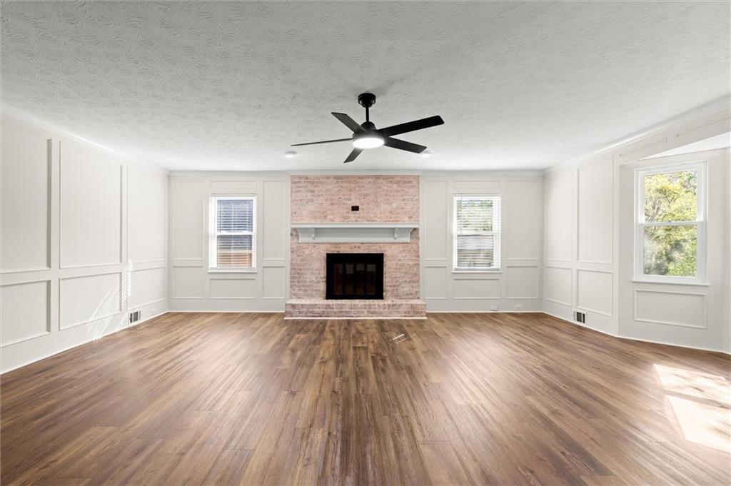 4922 Signal Court Southwest Lilburn, GA 30047 - Photo 18 of 49 an empty room with wooden floor a ceiling fan and windows