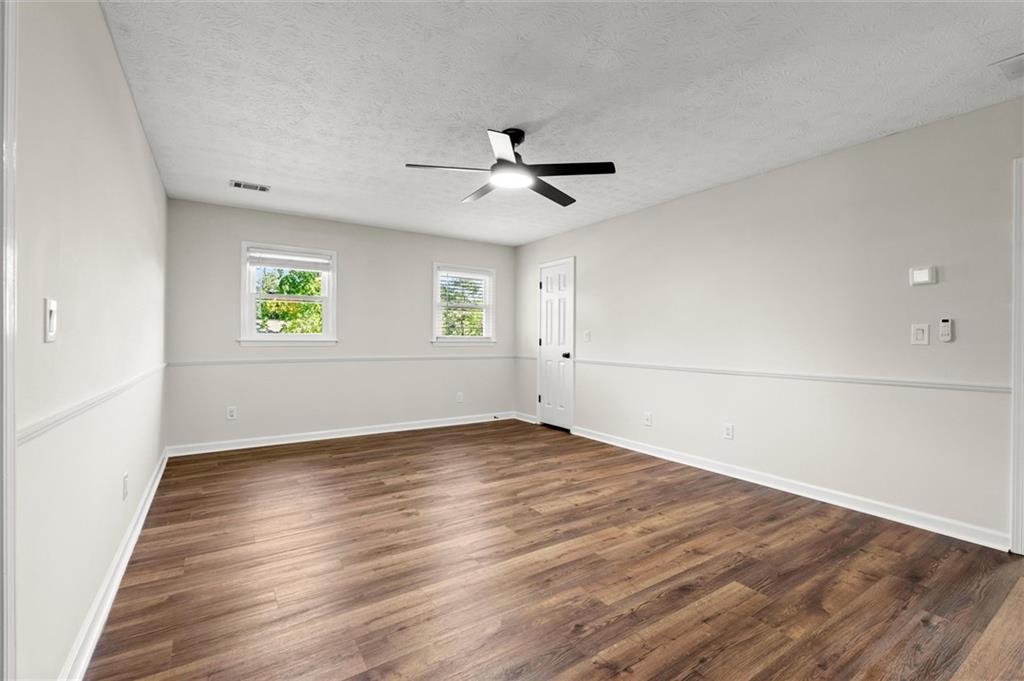 4922 Signal Court Southwest Lilburn, GA 30047 - Photo 24 of 49 an empty room with wooden floor and windows
