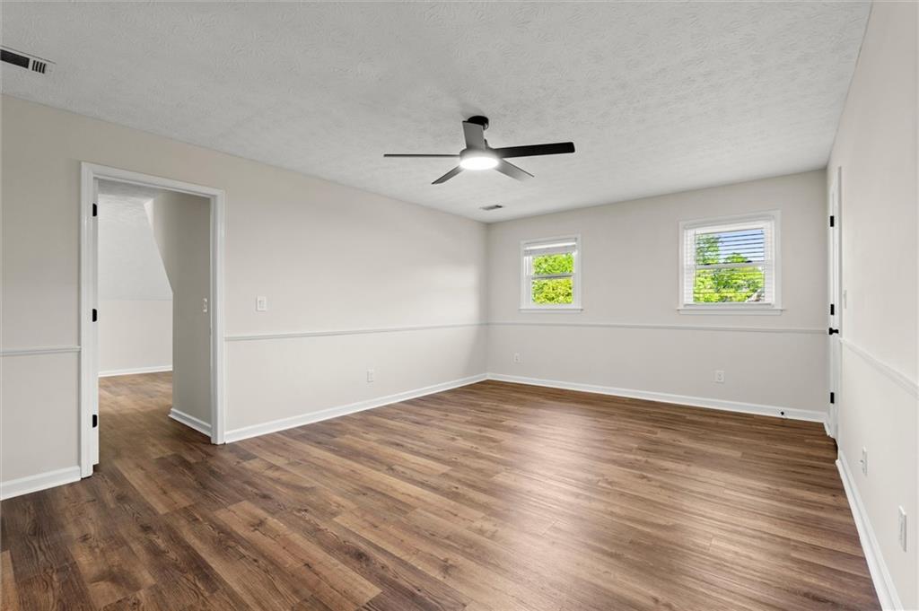 4922 Signal Court Southwest Lilburn, GA 30047 - Photo 25 of 49 an empty room with wooden floor and windows