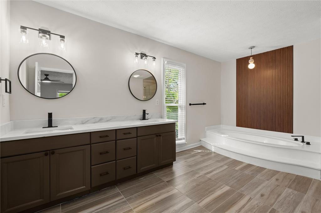 4922 Signal Court Southwest Lilburn, GA 30047 - Photo 26 of 49 a bathroom with a double vanity sink and a mirror