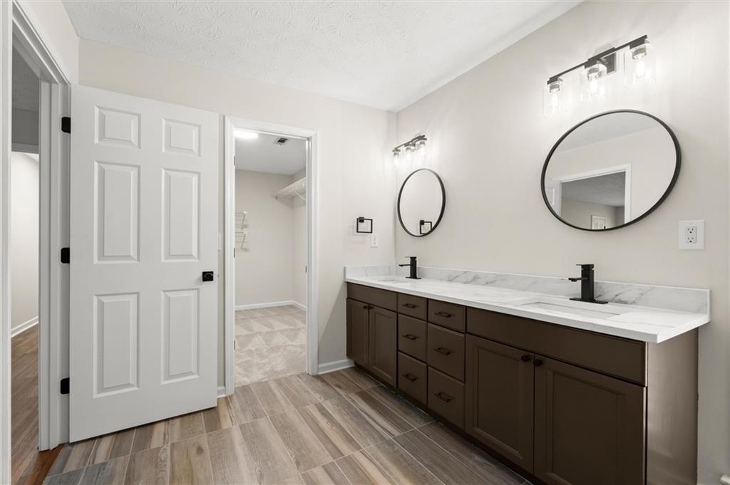 4922 Signal Court Southwest Lilburn, GA 30047 - Photo 28 of 49 a en suite bathroom with a granite countertop sink and a mirror