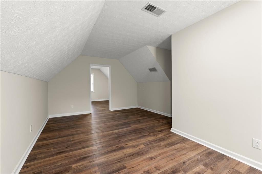 4922 Signal Court Southwest Lilburn, GA 30047 - Photo 30 of 49 an empty room with wooden floor and windows