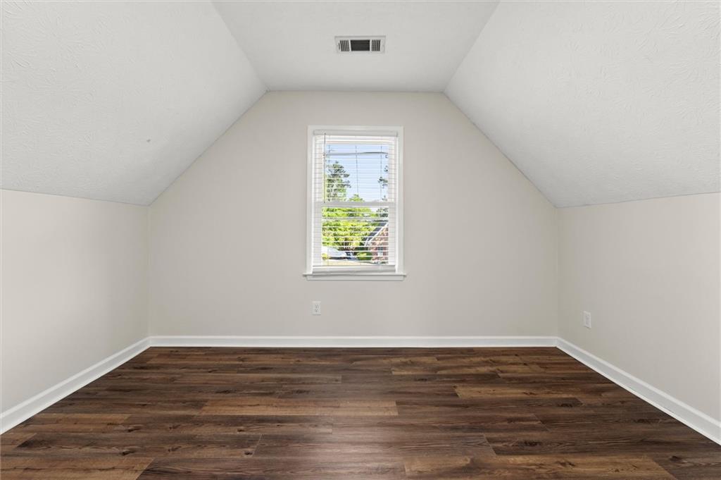 4922 Signal Court Southwest Lilburn, GA 30047 - Photo 32 of 49 a view of an empty room with wooden floor and a window
