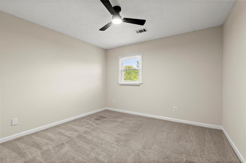 4922 Signal Court Southwest Lilburn, GA 30047 - Photo 40 of 49 an empty room with a window and a ceiling fan