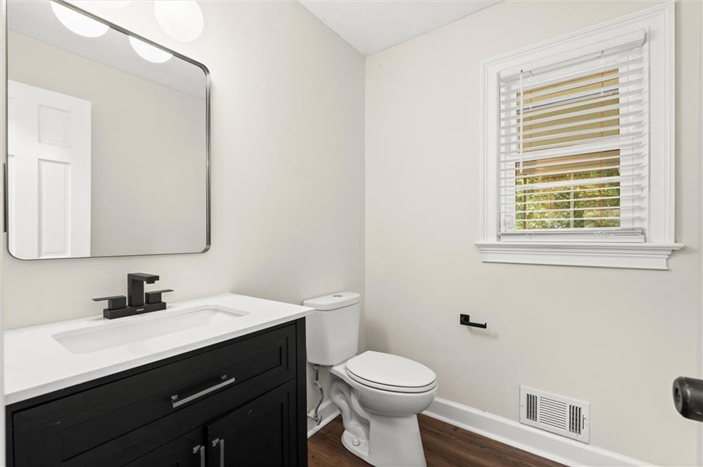4922 Signal Court Southwest Lilburn, GA 30047 - Photo 42 of 49 a bathroom with a toilet sink vanity and mirror