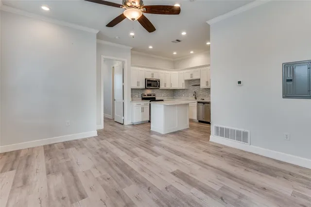 a view of kitchen with stainless steel appliances granite countertop cabinets and wooden floor