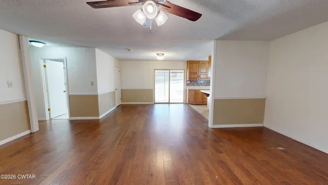 a view of empty room with wooden floor and window