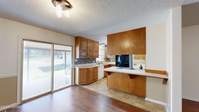 a kitchen with stainless steel appliances granite countertop a stove a sink and a refrigerator with wooden floor