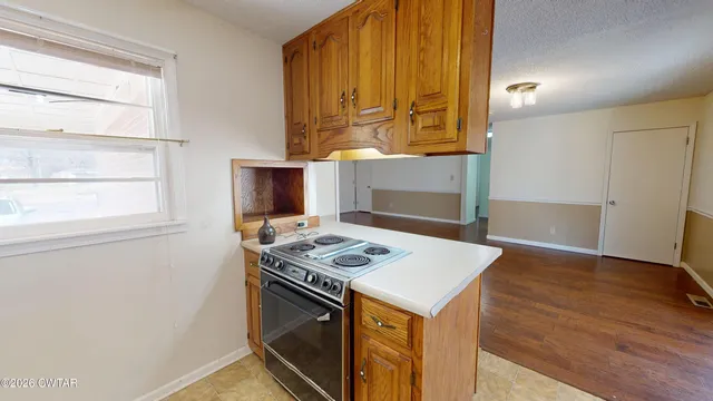 a kitchen that has a stove and a wooden floor