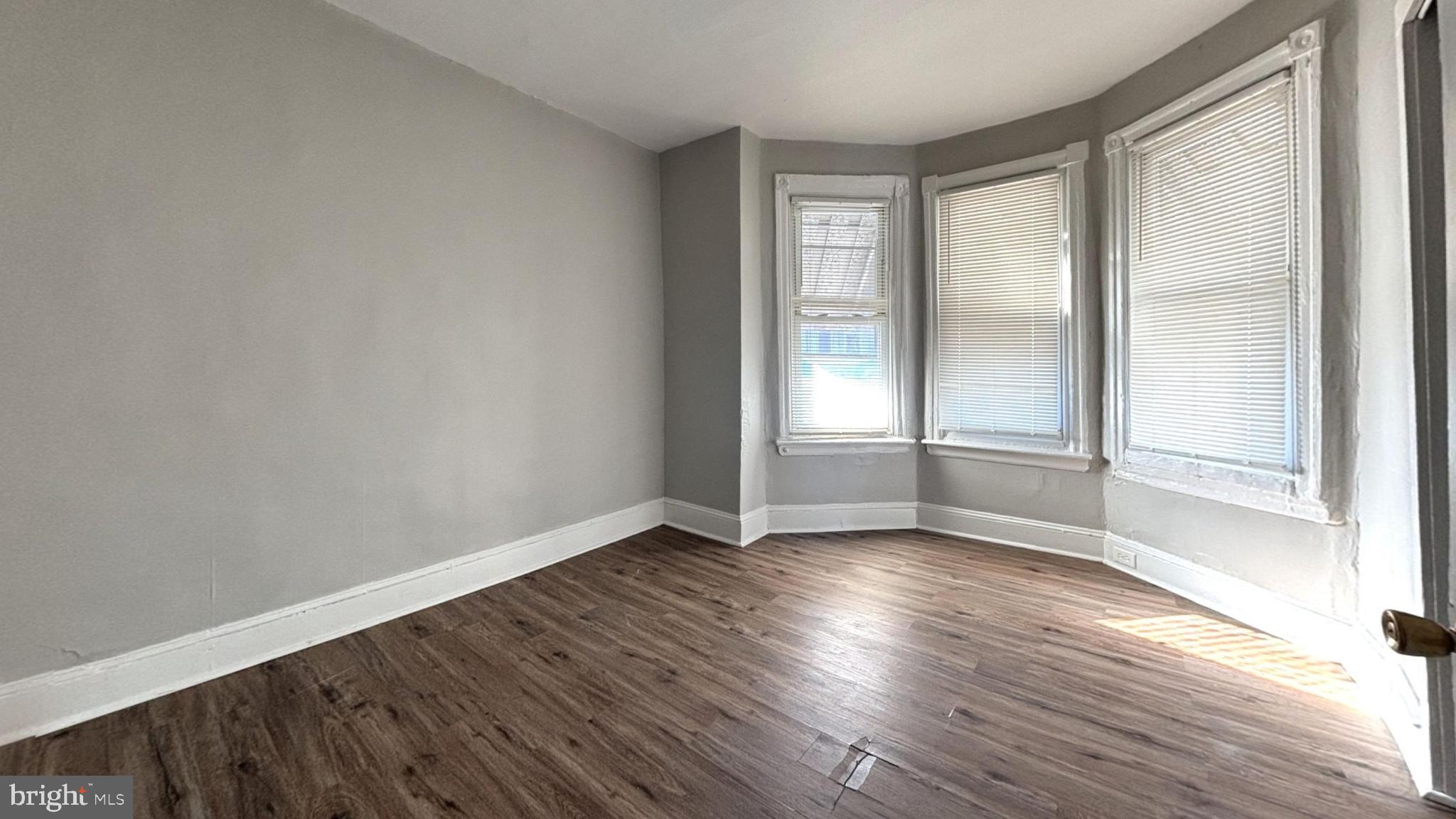 235 North Avondale Street Philadelphia, PA 19139 - Photo 3 of 8 an empty room with wooden floor and windows