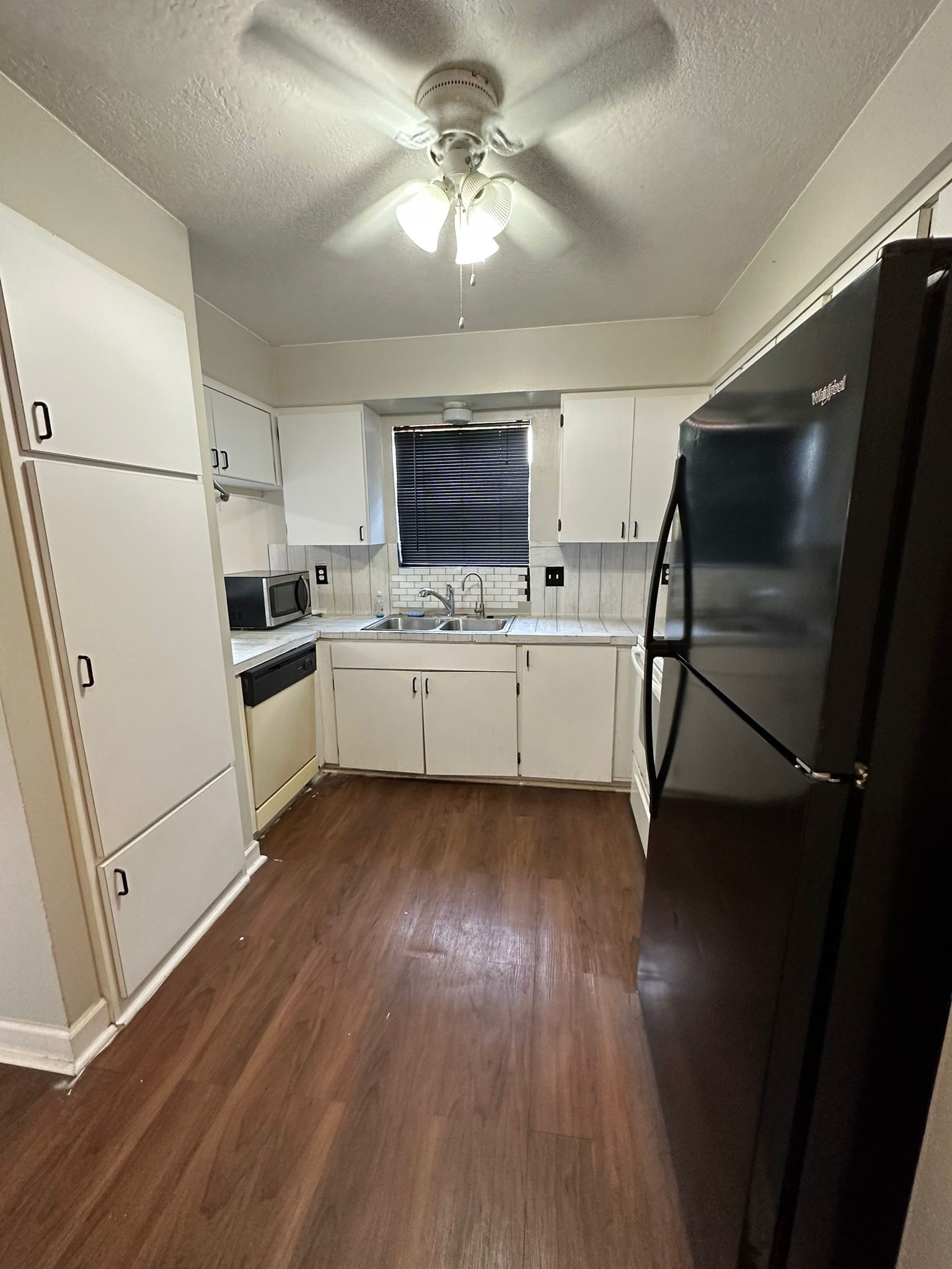 7305 South Gessner Road Houston, TX 77036 - Photo 8 of 24 a kitchen with cabinets and wooden floor