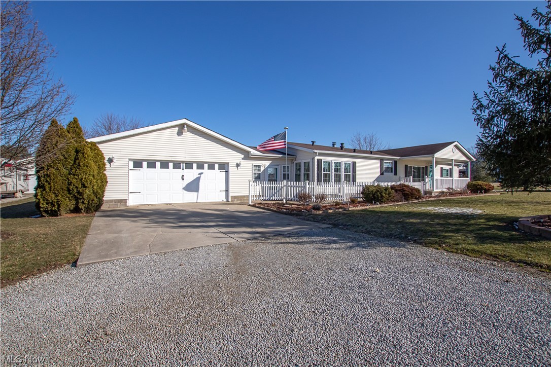 9459 Stone Road Litchfield, OH 44253 - Photo 39 of 50 Ranch-style house with a front lawn, a garage, and a porch