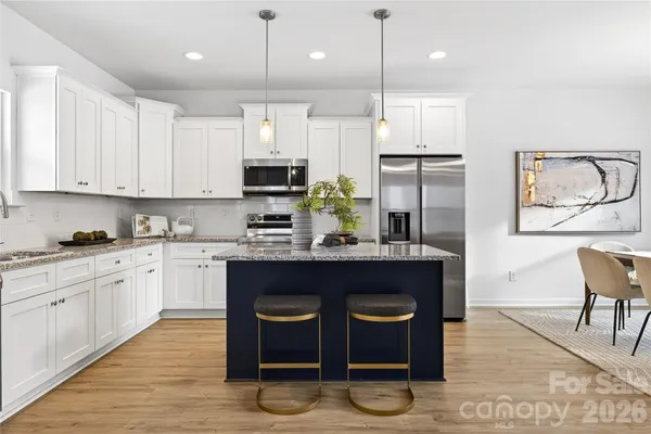 a kitchen with stainless steel appliances granite countertop a stove a sink and a refrigerator