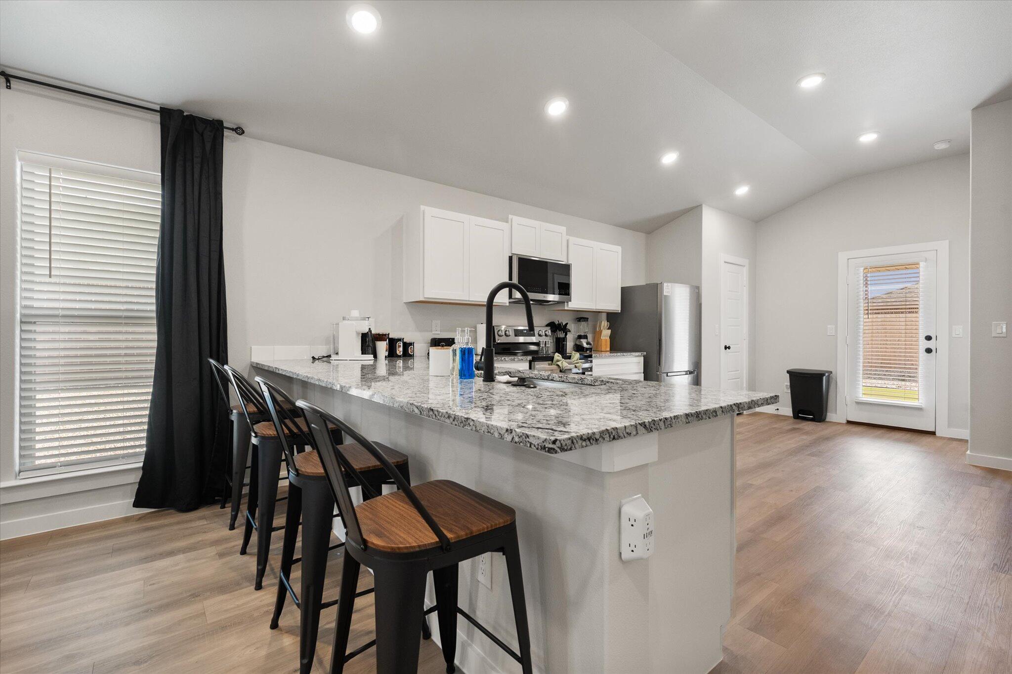 2146 Kokomo Avenue Lubbock, TX 79407 - Photo 4 of 10 a kitchen with stainless steel appliances granite countertop a dining table chairs and granite counter tops