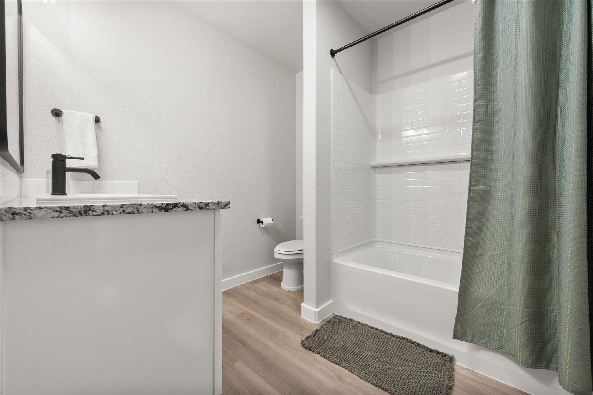 2146 Kokomo Avenue Lubbock, TX 79407 - Photo 6 of 10 a bathroom with a granite countertop sink a toilet and bathtub