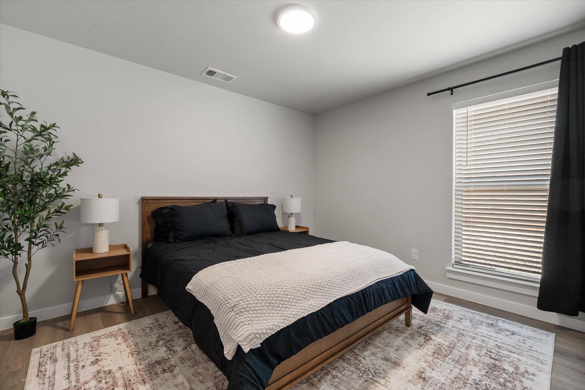 2146 Kokomo Avenue Lubbock, TX 79407 - Photo 7 of 10 a bedroom with a bed and a potted plant