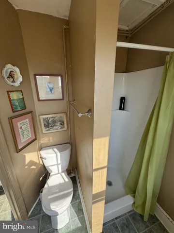 a bathroom with a toilet and a shower