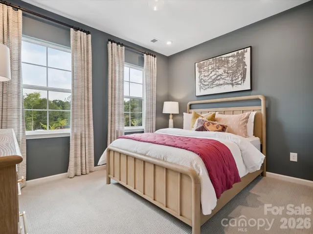 a spacious bedroom with a bed and a chandelier