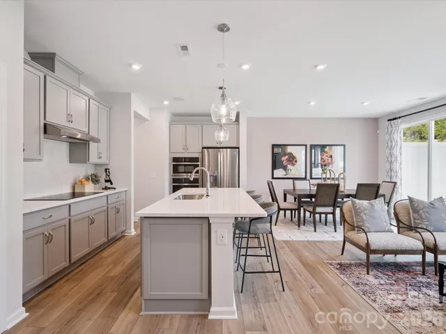 a kitchen with stainless steel appliances kitchen island granite countertop a sink and a refrigerator