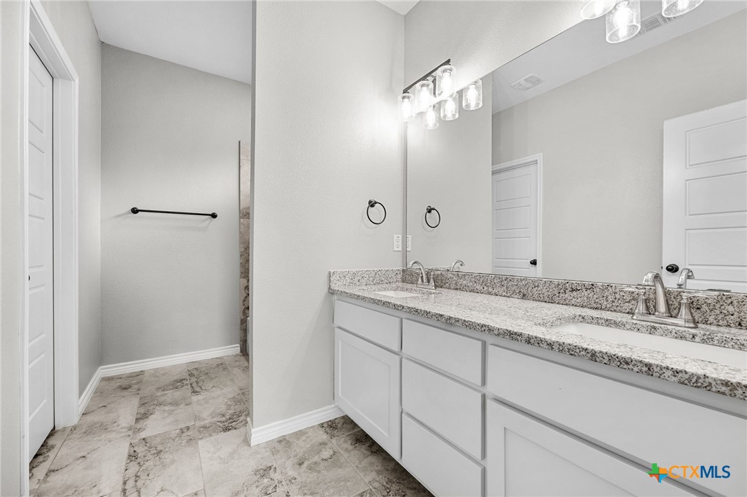 7713 Purvis Street Temple, TX 76502 - Photo 16 of 29 a bathroom with a granite countertop sink and a mirror