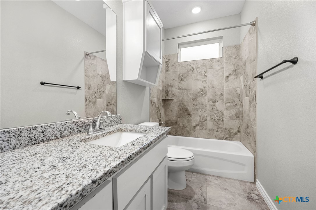 7713 Purvis Street Temple, TX 76502 - Photo 20 of 29 a bathroom with a granite countertop sink a toilet and bathtub