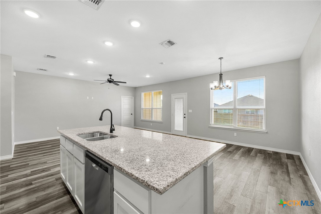 7713 Purvis Street Temple, TX 76502 - Photo 9 of 29 a kitchen with stainless steel appliances granite countertop a sink and a wooden floor