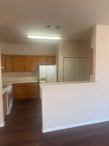 a view of a refrigerator in kitchen and wooden floor