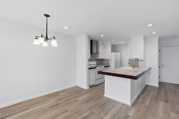 a kitchen with kitchen island stainless steel appliances a sink cabinets and wooden floor