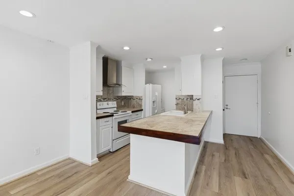 a kitchen with kitchen island a sink stove and wooden floor