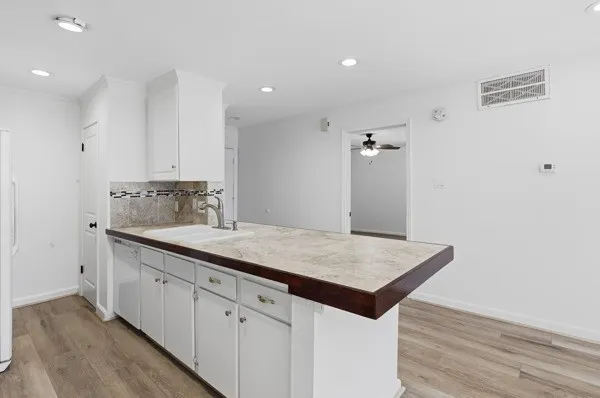 a kitchen with a sink cabinets and wooden floor