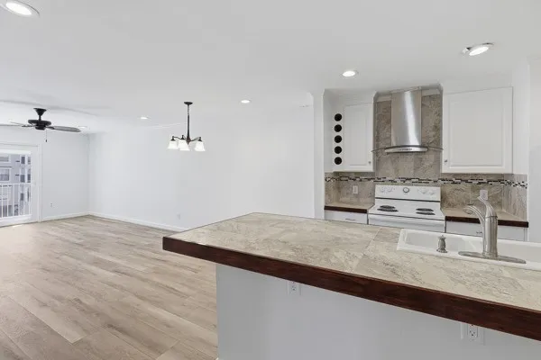 a kitchen with granite countertop a stove a sink and a refrigerator